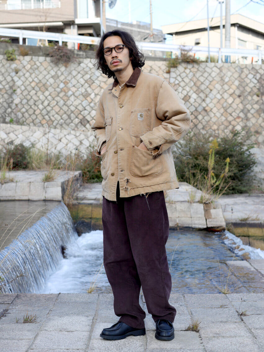 古着のカーハートのチョアジャケット、sk manor hillのコーデュロイパンツ、クレマンのチロリアンシューズ、オリバーピープルズのサングラスのコーデ
